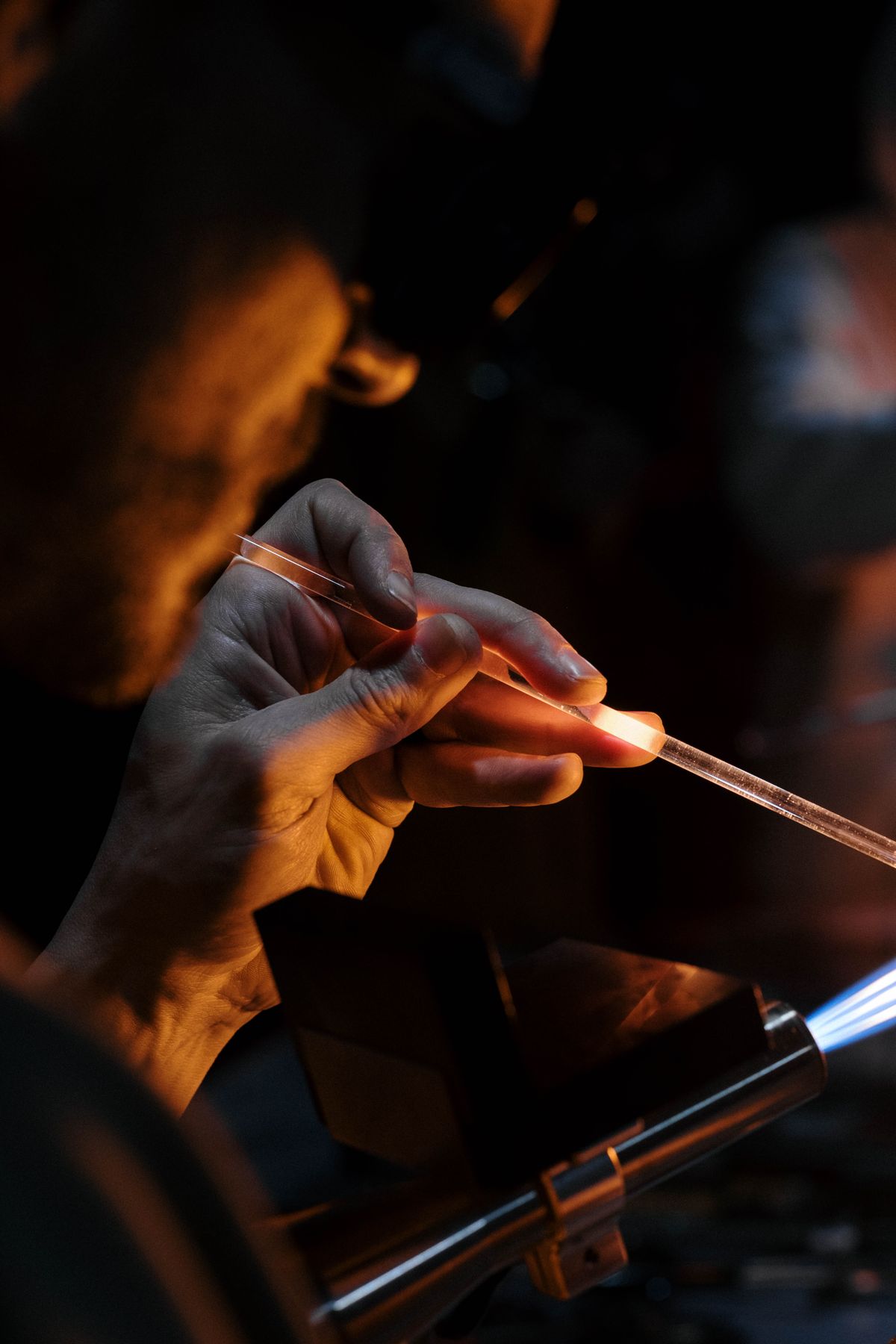 Artisan concentré à la tâche en soirée, à la lumière d'une lampe