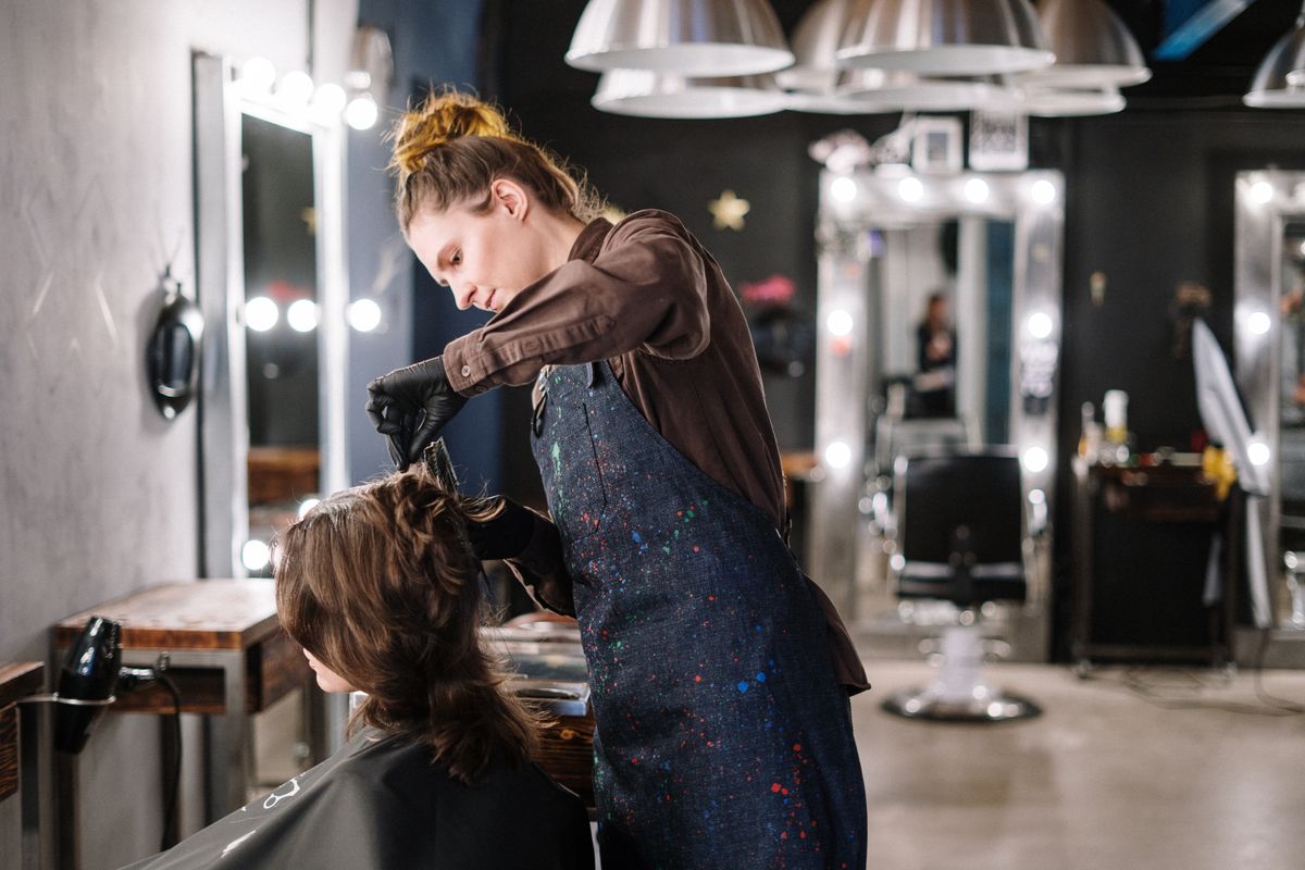 Coiffeuse en plein soin couleur sur une cliente
