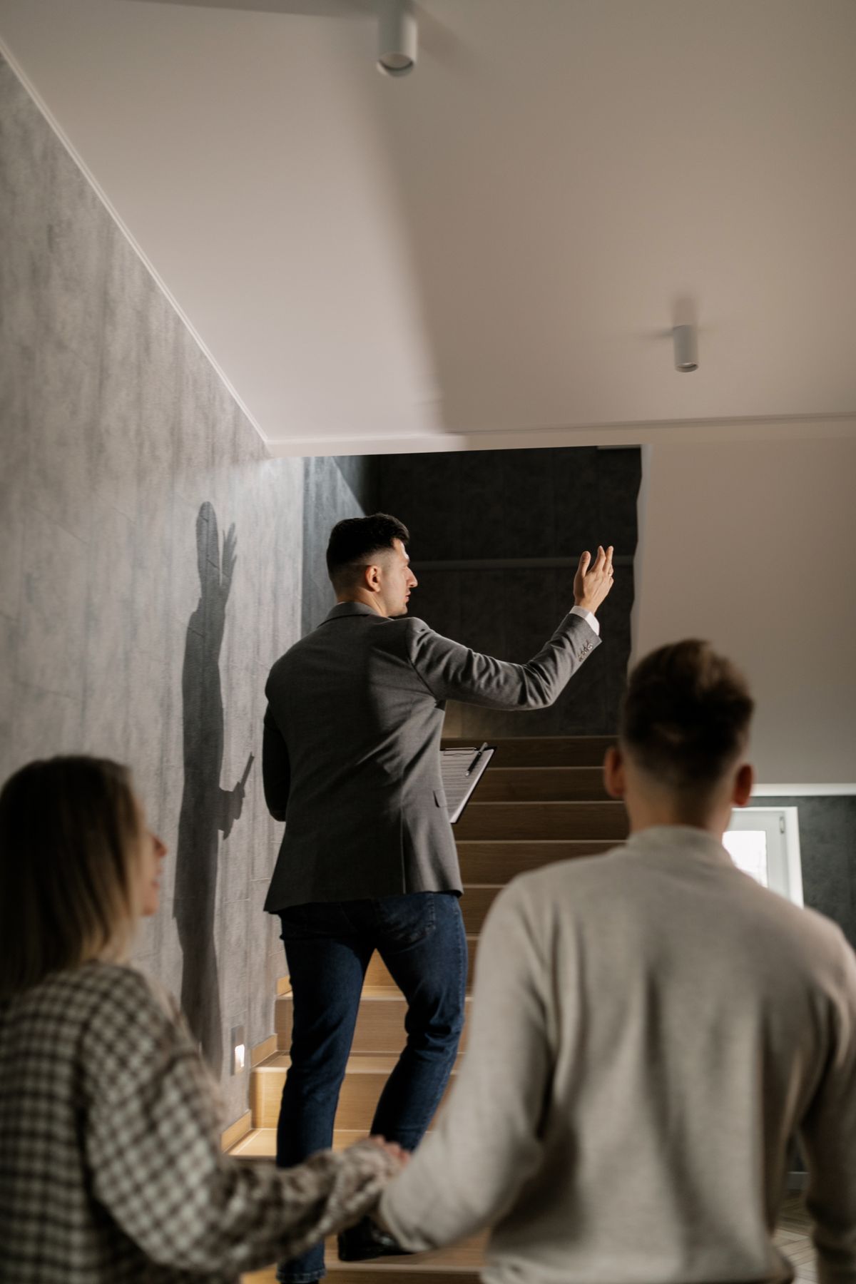 Agent immobilier faisant visiter un bien à un couple