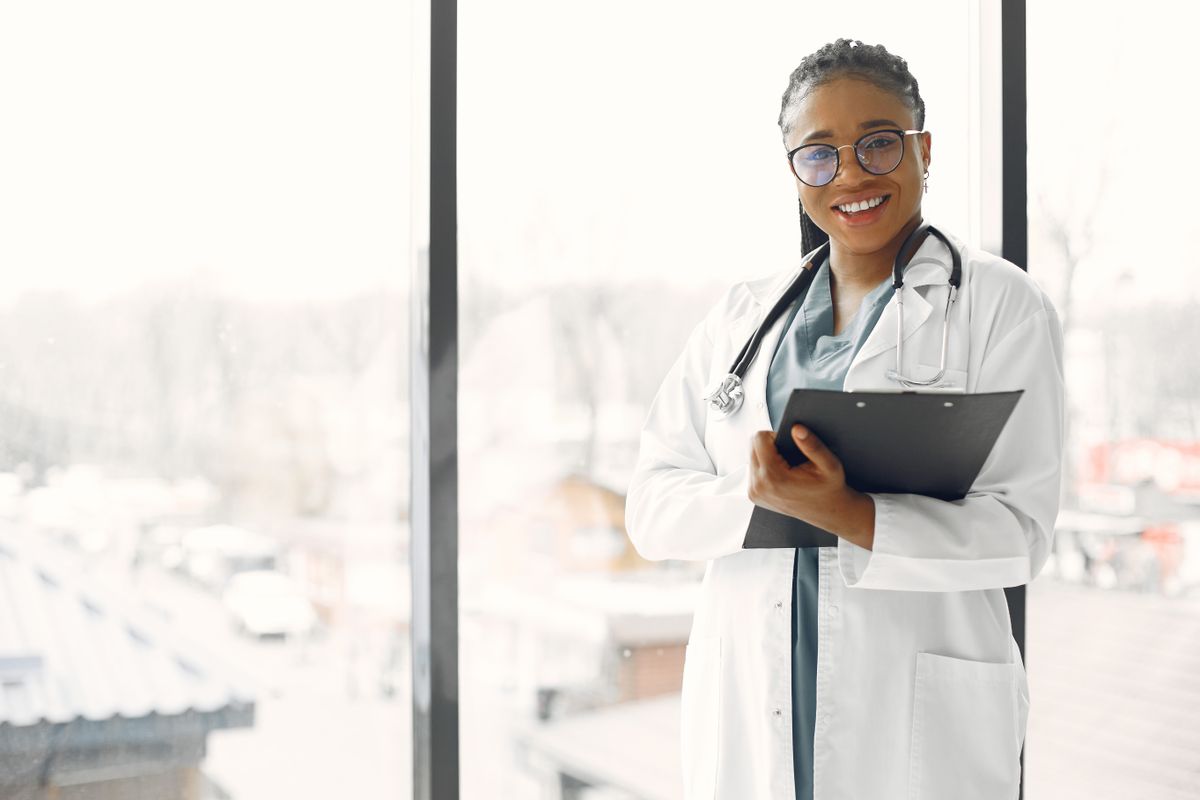Médecin en blouse blanche souriante avec stéthoscope